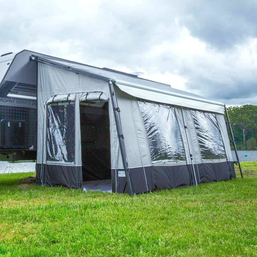A camper trailer on grass, equipped with a tent and an annexe for enhanced living space.